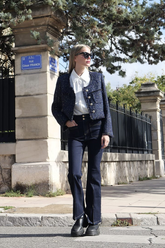 a lady in a white lapel shirt, a tweed sequins jacket and a pair of black jeans
